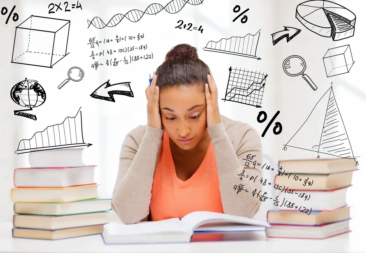 A girl is sitting at her desk with books.