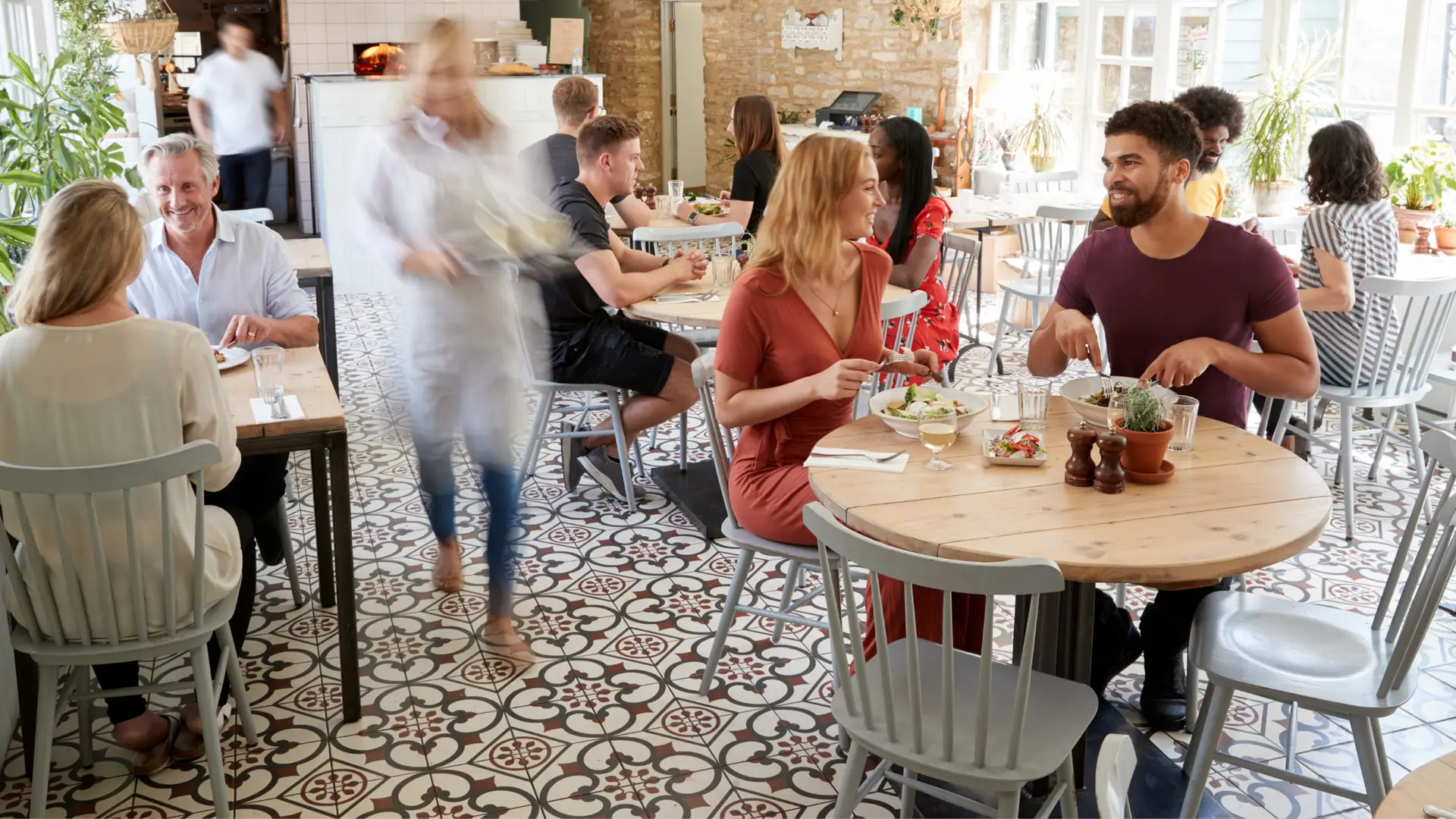 A group of people sitting at tables in a restaurant.